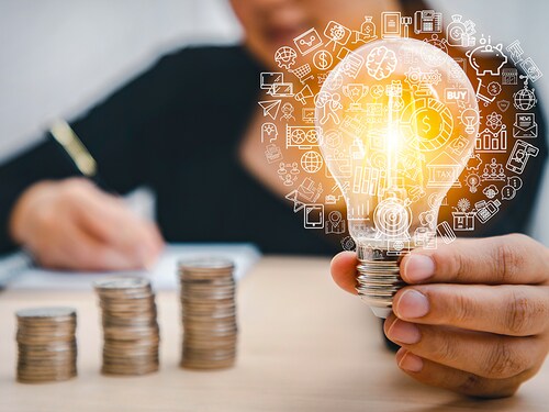Woman hand hold light bulb with icons work on the desk, Creativity and innovation are keys success. Concept of new idea and innovation with icons and light bulbs, Save the money, Freedom of thought.