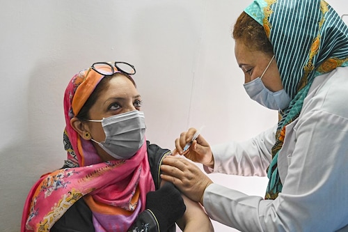 A health worker inoculates a woman with the jab of Covishield Covid-19 coronavirus vaccine during a special vaccination drive organised for government school teachers, staff members and their families in Srinagar, India. Image: Tauseef Mustafa / AFP