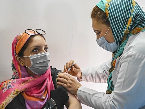A health worker inoculates a woman with the jab of Covishield Covid-19 coronavirus vaccine  during a special vaccination drive organised for government school teachers, staff members and their families in Srinagar, India. Image: Tauseef Mustafa / AFP