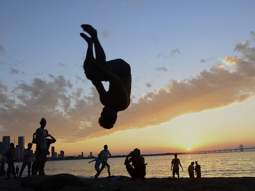 A boy performs a stunt at a beach in Mumbai on January on 9, 2022. (Photo by SUJIT JAISWAL / AFP)
