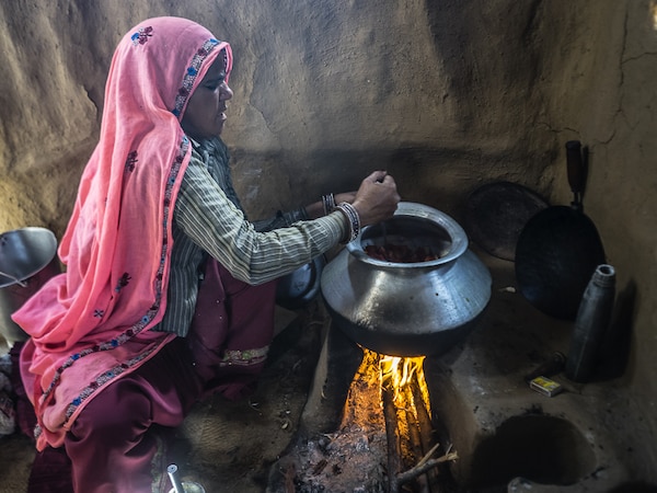 Rusirani Village, RAjashtan, circa February 2015. A woman cooking at her traditional kitchen in the village.