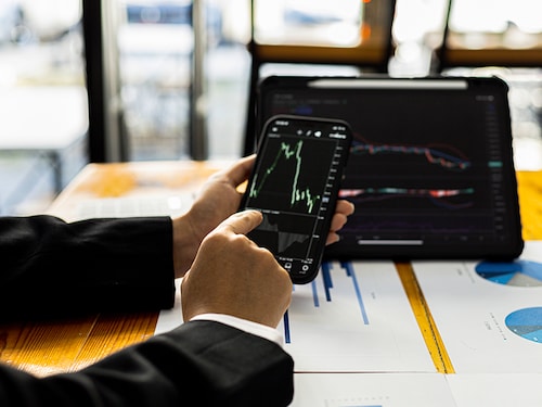 Two stock investors are brainstorming stock trading plans and reading stock market analysis, cryptocurrency investing, chart analysis and indicators to make profits in stocks. investment idea