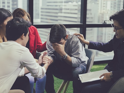 Mental health concept, group problematic young people talking with a guidance counselor. Group of therapy session sitting and talking. Diverse people talking, help and giving support.