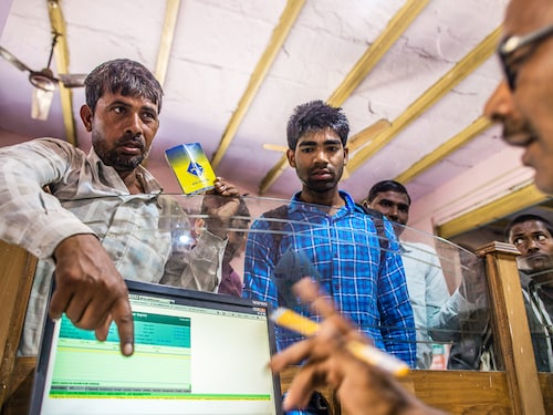 An employee serves customers inside a branch of Gramin Bank of Aryavat (GBA), sponsored by Bank of India, in the village of Khurana, Uttar Pradesh, India, on Monday, April 13, 2015. India has struggled to spur the expansion of banking services for the more than 800 million of its population living in the countryside. World Bank estimates show that more than two-thirds of India's 1.2 billion people live on less than $2 per day, and just 35 percent of adults have accounts at financial institutions. Photographer: Prashanth Vishwanathan/Bloomberg via Getty Images