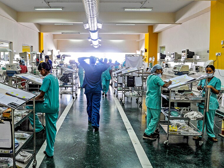 TO GO WITH India-health-hospital,FEATURE by Adam Plowright
In this picture taken on February 7, 2013 hospital staff work at one of the post-operative pediatrics observation and care units of the Narayana Hrudayalaya cardiac-care hospital in Bangalore. What if hospitals were run like a mix of Wal-Mart and a low-cost airline? The result might be something like the chain of "no-frills" Narayana Hrudayalaya clinics in southern India. Using pre-fabricated buildings, stripping out air-conditioning and even training visitors to help with post-operative care, the group believes it can cut the cost of heart surgery to an astonishing 800 USD. AFP PHOTO/Manjunath KIRAN        (Photo credit should read Manjunath Kiran/AFP via Getty Images)
