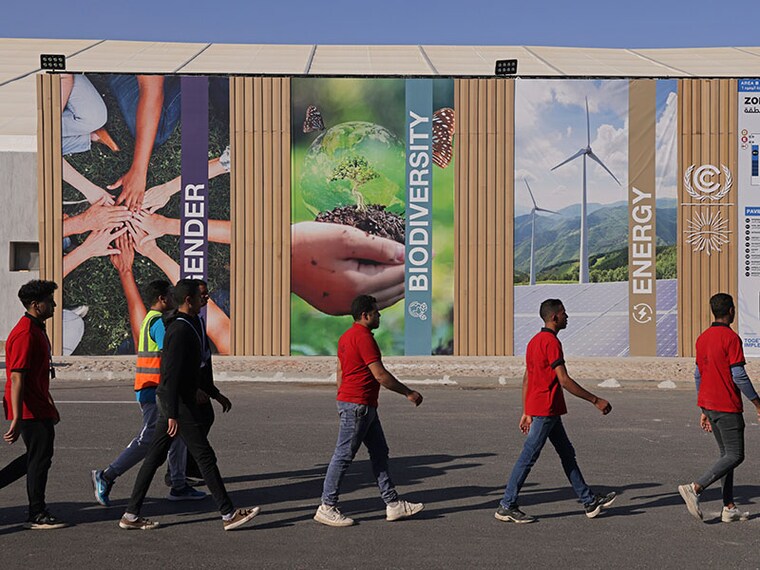 SHARM EL SHEIKH, EGYPT - NOVEMBER 06: Congress workers walk past thematic posters on the first day of the UNFCCC COP27 climate conference on November 06, 2022 in Sharm El Sheikh, Egypt. The conference is bringing together political leaders and representatives from 190 countries to discuss climate-related topics including climate change adaptation, climate finance, decarbonisation, agriculture and biodiversity. The conference is running from November 6-18. (Photo by Sean Gallup/Getty Images)
