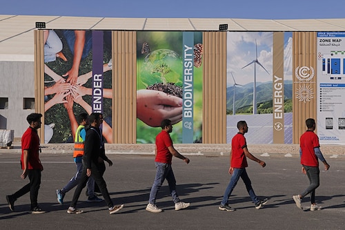 Congress workers walk past thematic posters on the first day of the UNFCCC COP27 climate conference on November 06, 2022 in Sharm El Sheikh, Egypt. The conference is bringing together political leaders and representatives from 190 countries to discuss climate-related topics including climate change adaptation, climate finance, decarbonisation, agriculture and biodiversity. The conference is running from November 6-18. Image: Sean Gallup/Getty Images