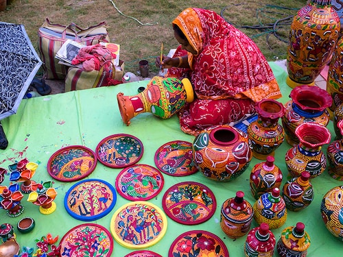 WEST BENGAL, INDIA - 2013/12/01: A woman is busy colouring earthenware. Pottery is quite famous in West Bengal. The small-scale industry of pottery is carried on mainly in the three districts of Bankura, Murshidabad and Midnapore. Pottery is made by forming a clay body into objects of a particular shape and heating them to high temperatures in a kiln. A clay body can be decorated before or after firing. Generally the women of Patua caste of the villages are involved with this industry. Sometimes men too engage themselves in making pottery. (Photo by Subhendu Sarkar/LightRocket via Getty Images)