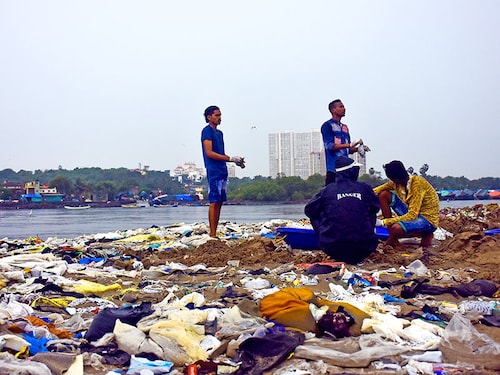 Volunteers pick-up trash during a beach clean-up program at Versova beach in Mumbai. Afroz Shah started cleaning work to remove tons of solid waste from the Versova beach in Mumbai, India. (Photo by: Azhar Khan/Majority World/Universal Images Group via Getty Images)