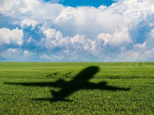 Shadow of the plane on the agricultural field. Concept of decarbonization and biofuel