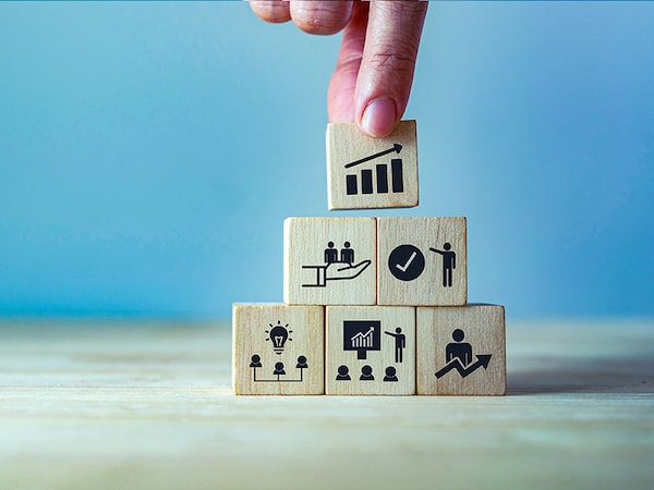 Business, personal development concept. Improving and developing  competency, performance. Hand holds wooden cubes with growth icon stading with brainstorm, training, mentor, support and improve icon