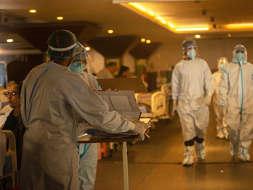 New Delhi, India- June 7 2021: A healthcare worker wearing a personal protective equipment (PPE) attends to Covid-19 patients inside a banquet hall temporarily converted to a Covid19 care centre
