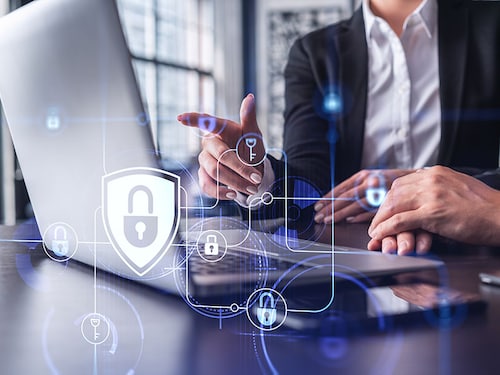 Two business people working on the project to protect cyber security of international company using laptop. Padlock Hologram icons. Teamwork concept.