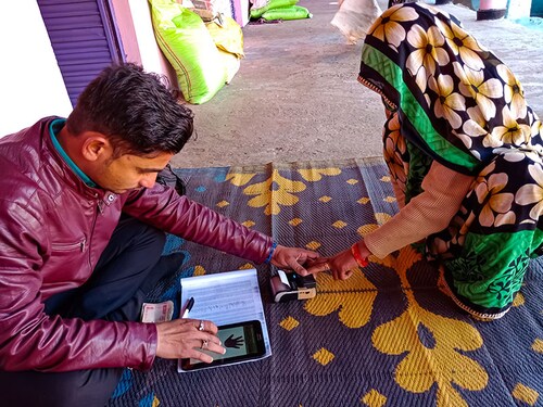 Katni, INDIA - January 2020: indian microfinance bank officer holded woman hand during loan disbursement procedure