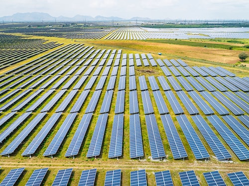 BENGALURU, INDIA - OCTOBER 11: An aerial view of the Pavagada Solar Park on October 11, 2021 in Kyataganacharulu village, Karnataka, India. As the countdown to the United Nations Climate Change Conference (COP26) at Glasgow begins, India is in a formidable position to lead climate change conversations as the country is on its way to meet its renewable energy target of 175GW by 2022, with solar power alone contributing to 100GW. In a clutch of villages around the Pavagada solar park in the southern state of Karnataka where nearly 13,000 acres of land has been acquired on lease for 28 years to produce 2050MW of electricity, economic inequity is becoming apparent — while farmers with large land holdings have clearly benefitted, poor farmers with no land have further been pushed to the margins with rising unemployment, lack of basic infrastructure, and a loss of their cultural identity. (Photo by Abhishek Chinnappa/Getty Images)