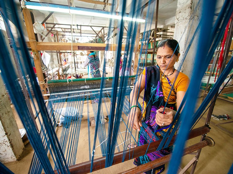 Khargone, Madhya Pradesh, India- July 14 2016: A woman weaver prepares threads to make maheshwari saree with a handloom at workshop. example of Women empowerment.