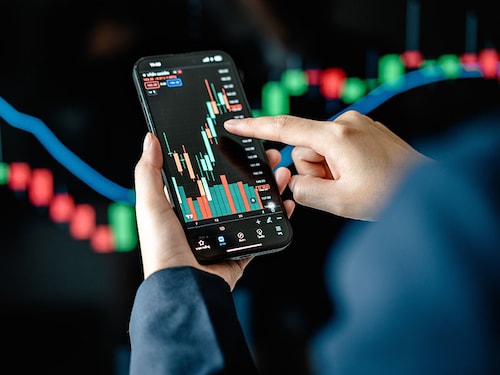 Investors analyze the data stock market index via smartphone screen to trade the stock chart for planning investments take profit, trade stock exchange market and cryptocurrency data, financial.