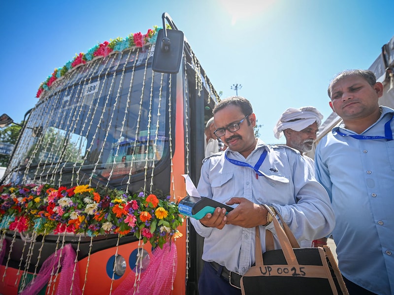 A bus conductor seen using the new digital ticketing machine given to them during inauguration of interstate DTC AC bus service from Delhi to Baraut in Uttar Pradesh at ISBT Kashmiri Gate on September 23, 2025 in New Delhi, India.
