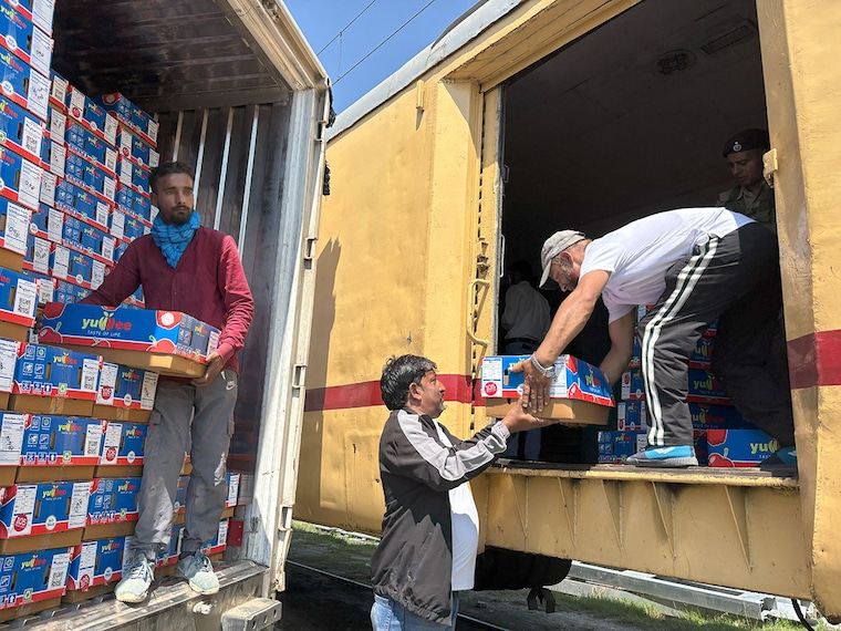 Labourers seen loading boxes of apples in the first parcel train from Kashmir to Delhi from Budgam station on September 11, 2025. Apple growers in Kashmir are facing heavy losses due to the closure of the Srinagar-Jammu National Highway as it has left their produce stranded and threatened their livelihoods. Indian Railways has introduced daily train services for cargo and parcel for perishable produce from Kashmir Valley, connecting Budgam with Adarsh Nagar, Delhi. Image: Waseem Andrabi/Hindustan Times via Getty Images