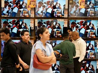 People stand in an electronics showroom in Mumbai, India, on September 22, 2025. With the new Goods and Services Tax (GST) rates coming into effect on Monday, several items including electronics, kitchen staples, medicines and automobiles have become cheaper--a festival season relief for consumers. Image: Indranil Aditya/NurPhoto via Getty Images