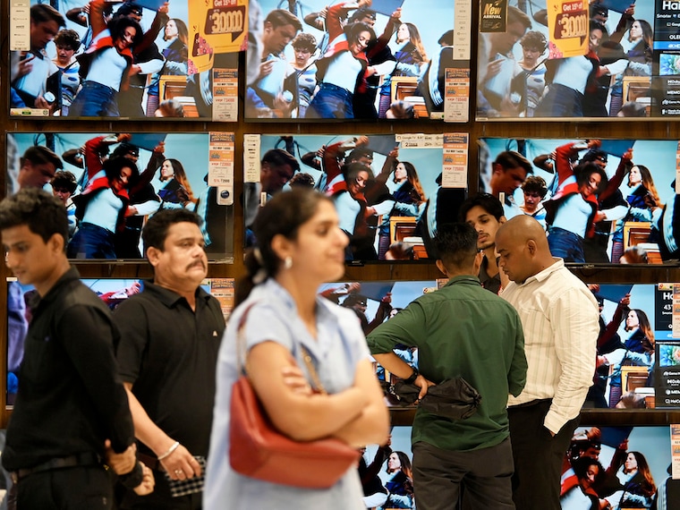 People stand in an electronics showroom in Mumbai, India, on September 22, 2025. With the new Goods and Services Tax (GST) rates coming into effect on Monday, several items including electronics, kitchen staples, medicines and automobiles have become cheaper--a festival season relief for consumers. Image: Indranil Aditya/NurPhoto via Getty Images