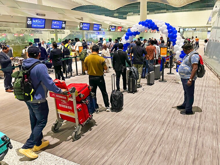 Passengers queue to check-in for a direct flight from Guangzhou to Kolkata at the international airport in Guangzhou on October 27, 2025. Passengers of the first direct flight between India and China in five years touched down on October 27, after Asia's giants lifted a long-term air travel suspension as they cautiously rebuild relations.