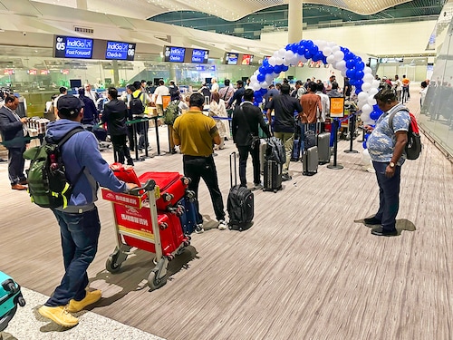 Passengers queue to check-in for a direct flight from Guangzhou to Kolkata at the international airport in Guangzhou on October 27, 2025. Passengers of the first direct flight between India and China in five years touched down on October 27, after Asia's giants lifted a long-term air travel suspension as they cautiously rebuild relations.