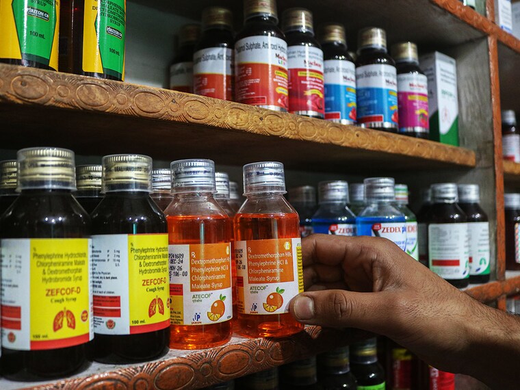 An employee arranges cough syrups at a pharmacy. Indian authorities say they investigate whether contaminated cough syrup causes the deaths of many children, all aged below five years, in the states of Madhya Pradesh and Rajasthan since late August. Image: Firdous Nazir/NurPhoto via Getty Images