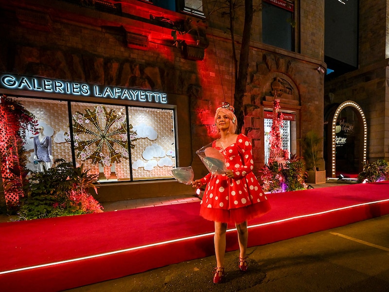 An artist performs in front of the Galeries Lafayette store during its opening in Mumbai on November 16, 2025. The globe's biggest luxury brands have dreamt of India's vast consumer base for decades, but navigating the market has proven to be a complex task. French retailer Galeries Lafayette is the latest to try its luck, opening its first Indian store in Mumbai, the country's financial capital.