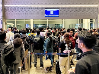 Passengers crowd outside a boarding gate as they wait to board a delayed IndiGo flight at Indira Gandhi International airport in New Delhi, India, December 3, 2025. Passengers crowd outside a boarding gate as they wait to board a delayed IndiGo flight at Indira Gandhi International airport in New Delhi, India, December 3, 2025.