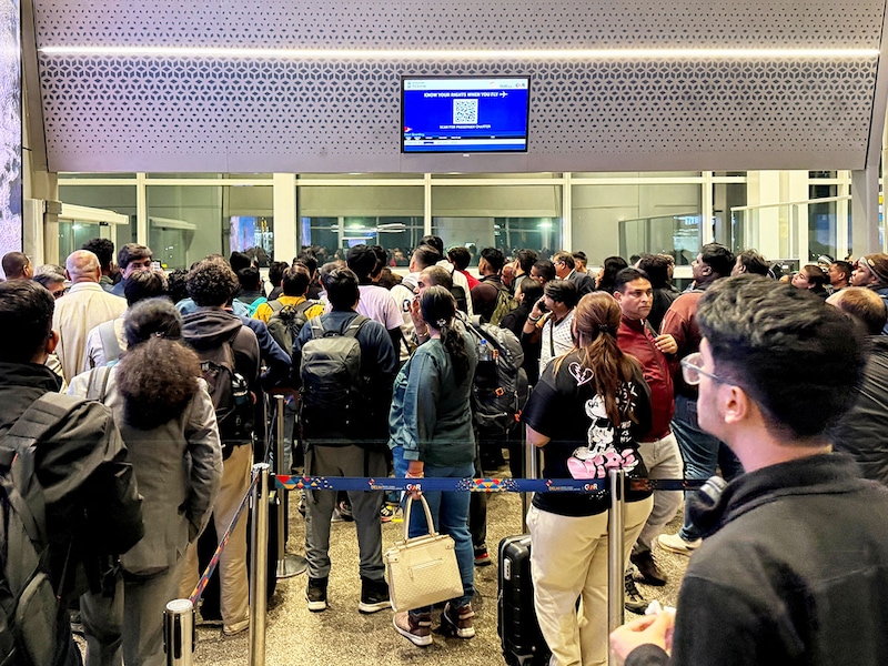 Passengers crowd outside a boarding gate as they wait to board a delayed IndiGo flight at Indira Gandhi International airport in New Delhi, India, December 3, 2025.