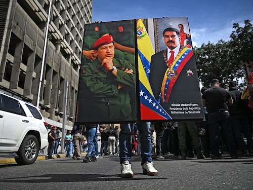 A supporter of Venezuela's President Nicolas Maduro holds a portrait of him and another of late Venezuela's leader (1999-2013) Hugo Chavez in Caracas on January 3, 2026, after US forces captured Maduro. Photo by Federico Parra / AFP
A supporter of Venezuela's President Nicolas Maduro holds a portrait of him and another of late Venezuela's leader (1999-2013) Hugo Chavez in Caracas on January 3, 2026, after US forces captured Maduro. Photo by Federico Parra / AFP
