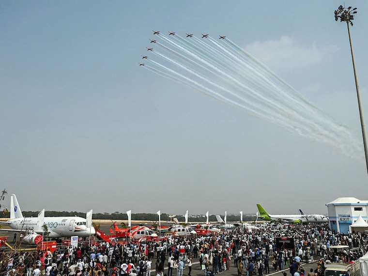 Visitors watch the Indian Air Force's Surya Kiran aerobatics team performing during an air show at the Begumpet Airport in Hyderabad on January 30, 2026.