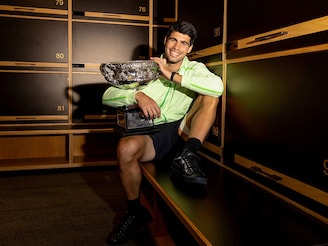 This handout picture released by Tennis Australia on February 2, 2026, shows Spain's Carlos Alcaraz poses with the Norman Brookes Challenge Cup at the locker room after defeating Serbia's Novak Djokovic in the men's singles final on Day 15 of the Australian Open tennis tournament in Melbourne. (Photo by Fiona HAMILTON / TENNIS AUSTRALIA / AFP)