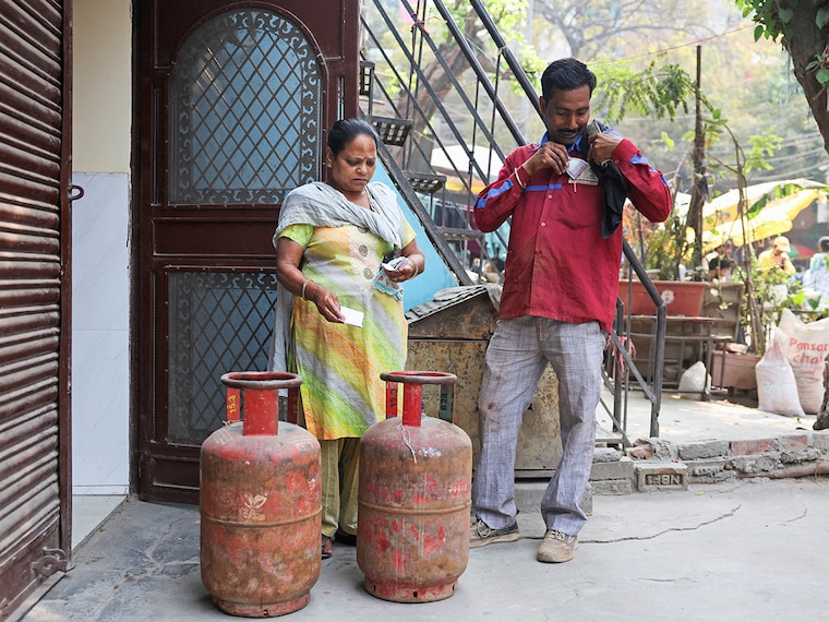 A worker delivers an LPG cylinder to a house, amid supply disruptions following the U.S.-Israeli conflict with Iran, in New Delhi, India, March 10, 2026.