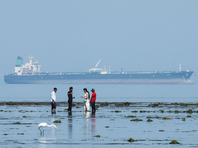 The crude oil tanker Desert Kite carrying Russian oil glides in the background, while tourists watch marine life at Narara Marine National Park in the Arabian Sea, Gujarat, March 11 , 2026.