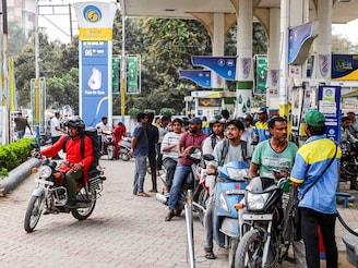 People line up to refuel their vehicles at a Bharat Petroleum (BP) fuel station in Varanasi on March 10, 2026. The oil price spike caused by the war in the Middle East has sparked exasperation at petrol pumps around Asia, where many economies are heavily dependent on fossil fuel imports. Photo by Niharika Kulkarni / AFP
