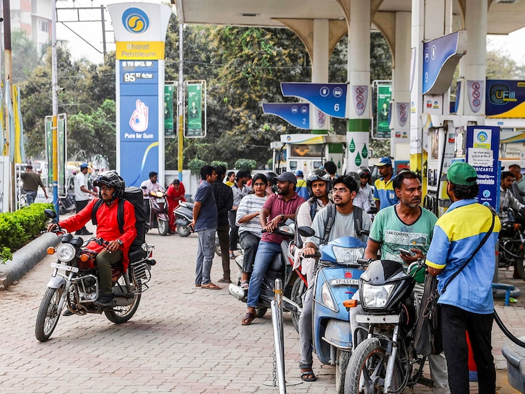 People line up to refuel their vehicles at a Bharat Petroleum (BP) fuel station in Varanasi on March 10, 2026. The oil price spike caused by the war in the Middle East has sparked exasperation at petrol pumps around Asia, where many economies are heavily dependent on fossil fuel imports. Photo by Niharika Kulkarni / AFP