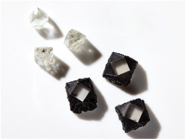 Rough natural diamonds alongside uncut lab grown stones