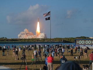 People watch as NASA's Artemis II Space Launch System rocket carrying the Orion spacecraft lifts off from  Kennedy Space Center on April 1, 2026 in Cape Canaveral, Florida. Photo by Chip Somodevilla/Getty Images