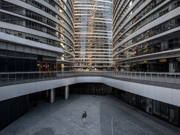 A pedestrian walks in an empty commercial and office building compound in Beijing on March 19, 2020. Fears are growing that the worldwide economic downturn delivered by the coronavirus pandemic could be especially deep and lengthy, with recovery limited by continued anxiety. Image: Gilles Sabrié/The New York Times