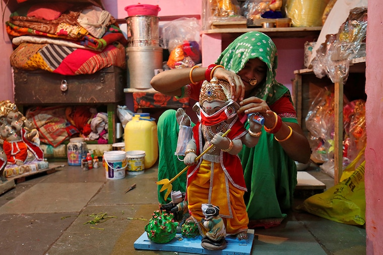 A woman puts a face mask on an idol of Hindu god Ganesh, the deity of prosperity, at her workshop ahead of the Ganesh Chaturthi festival, amidst the coronavirus disease (COVID-19) outbreak, in Ahmedabad, India, August 18, 2020.
