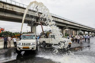 Municipal workers use a water pump to purge a flooded underpass after heavy rains in Gurugram, India