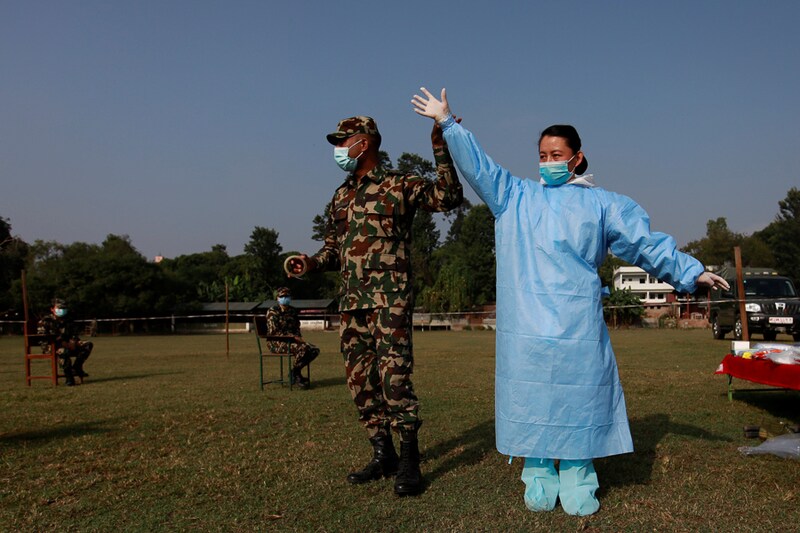 A female soldier wearing PPE takes part in a training on handling bodies of coronavirus victims in Kathmandu, Nepal, October 15, 2020. Women soldiers are being deployed to handle Nepal"s coronavirus deaths in a majority-Hindu country where it is still a cultural taboo for women to touch a dead body.