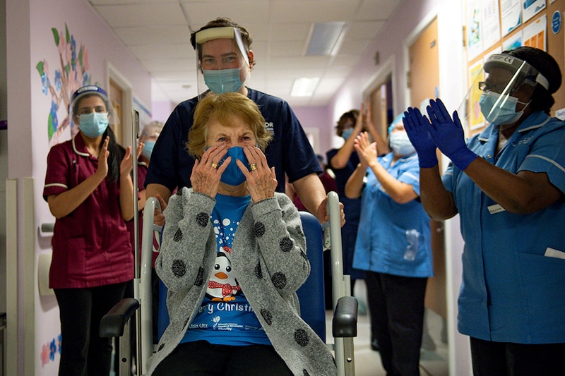 Margaret Keenan, 90, is applauded by staff as she returns to her ward after becoming the first person in Britain to receive the Pfizer/BioNTech COVID-19 vaccine at University Hospital, at the start of the largest ever immunisation programme in the British history, in Coventry, Britain December 8, 2020. Britain is the first country in the world to start vaccinating people with the Pfizer/BioNTech jab.