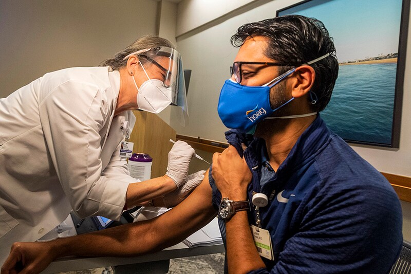 Nurse Joy Kersey gives a COVID-19 vaccine to Dr. Usman Shah at Hoag Hospital in Newport Beach, CA on Thursday, December 17, 2020. Shah was the first to receive the BioNTech vaccine that was administered to front-line nurses and doctors. The hospital received 1,950 doses in its first shipment.