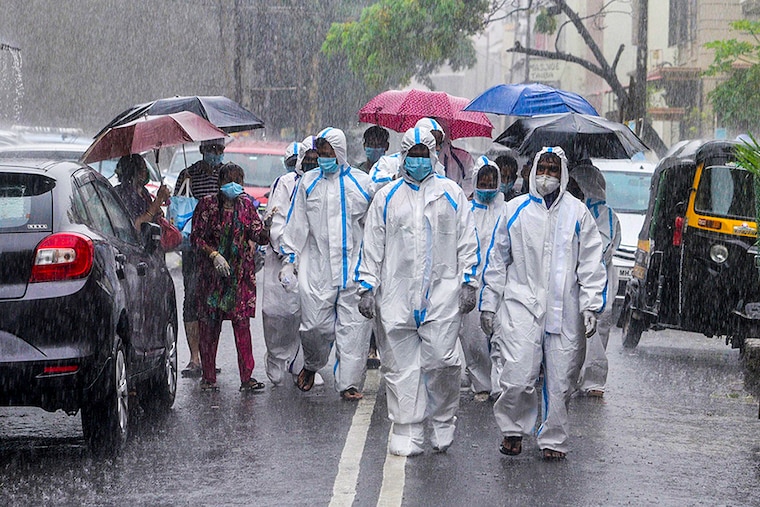 Healthcare staff walk around Mumbai"s Malad in pouring rain to conduct door-to-door check-up on Sunday.