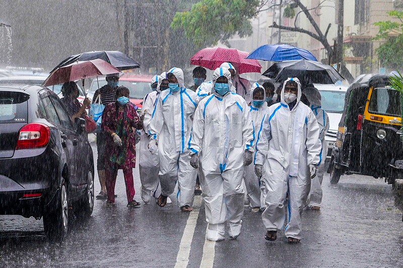 Healthcare staff walk around Mumbai"s Malad in pouring rain to conduct door-to-door check-up on Sunday.