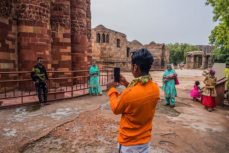 Tourists take their pictures in front of the United Nations Educational, Scientific and Cultural Organisation (UNESCO) World Heritage Site of Qutub Minar complex, on July 06, 2020 in New Delhi, India. Barring the iconic Taj Mahal, the Archeological Survey of India (ASI) Monday opened for the public the historical monuments which had remained closed for several months after the Indian government imposed a nationwide lockdown on March 25 to curb the spread of coronavirus which has so far claimed 20,000 lives and caused nearly 7 hundred thousand infections besides severely affecting the country"s economy. Security guards posted at several of the monuments, however, said there had hardly been any visitors as people were still apprehensive about catching the deadly virus. Under new guidelines, visitors can only visit ASI-protected monuments by acquiring online tickets, wearing masks, maintaining social distancing and undergoing temperature checks