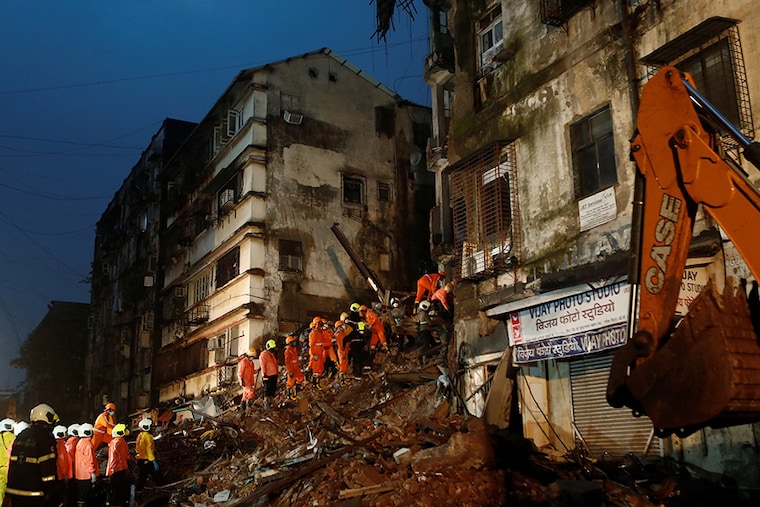 National Disaster Response Force (NDRF) and fire brigade personnel look for survivors trapped in the debris after part of a residential building collapsed following heavy rains in Mumbai, India, July 16, 2020.